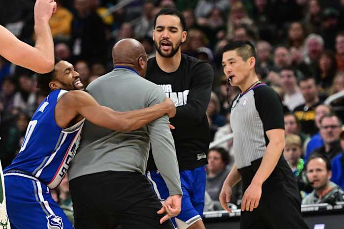 Sacramento Kings head coach Mike Brown is restrained by guard Malik Monk (0) as he argues with referee Intae Hwang i